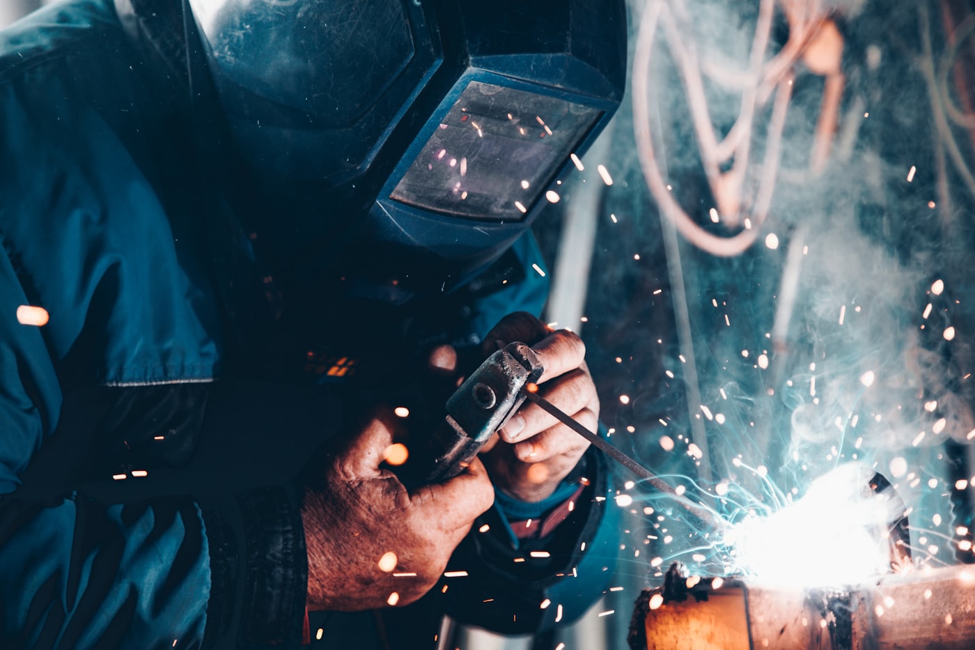 A welder working on a production line amid sparks