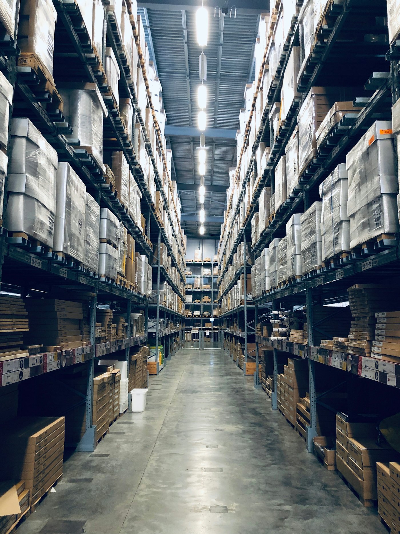 A tall warehouse aisle with fully stocked pallet racking